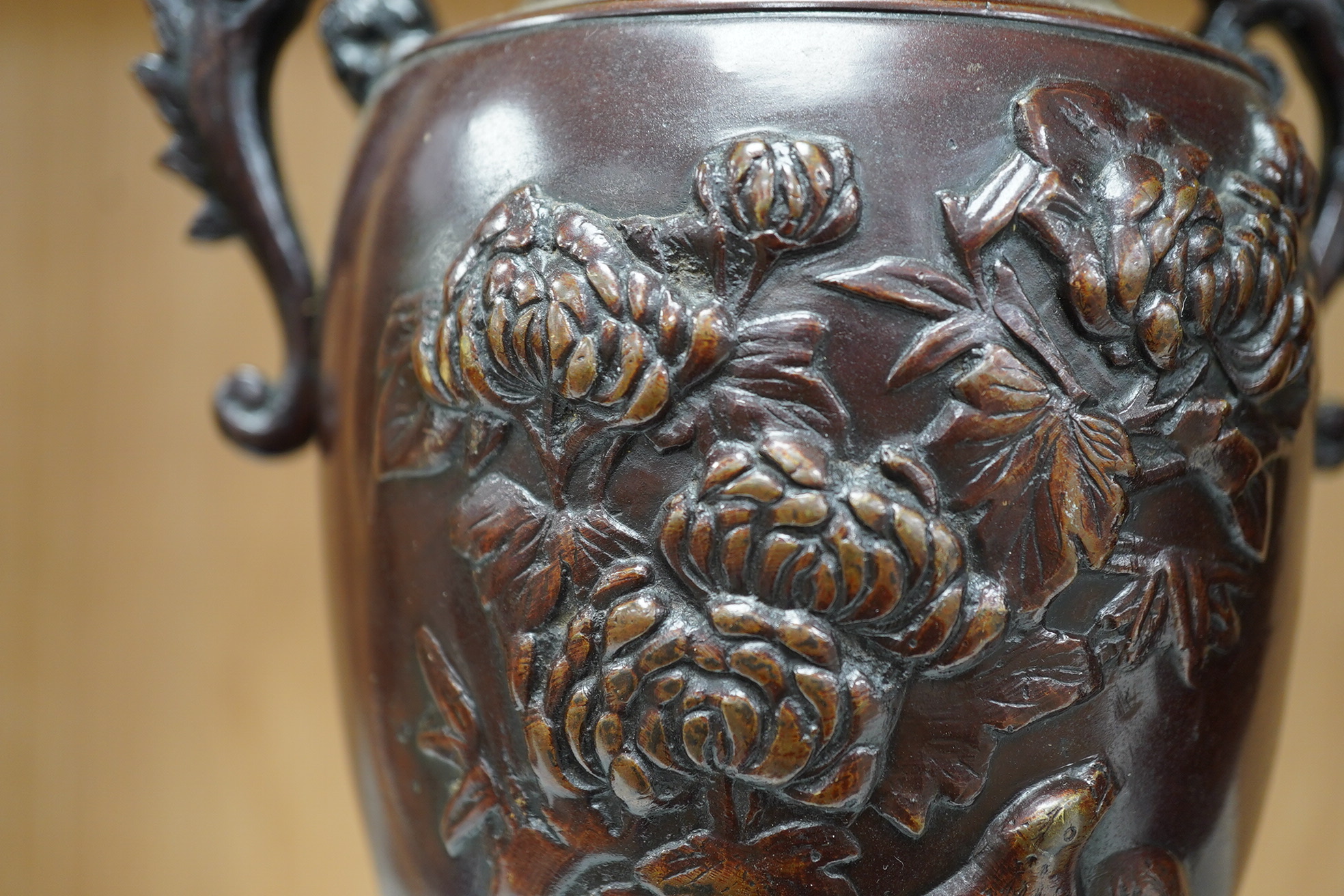 A pair of Japanese two handled bronze vases decorated in relief with birds and flowers, 26cm high. Condition - good